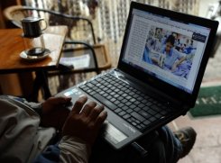 Một người đàn ông đang đọc tin tức trên mạng với chiếc laptop                                                                  của mình tại một tiệm cà phê ở trung tâm Hà Nội ngày 15/1/2013.